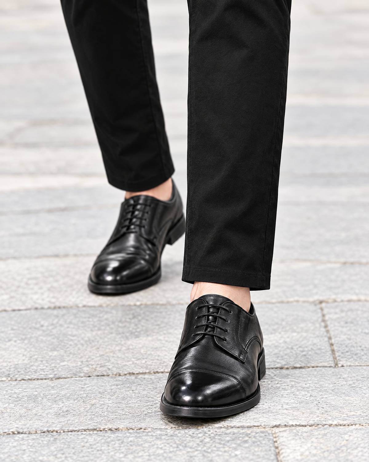 Hem of men's black stretch chino pants over black leather shoes