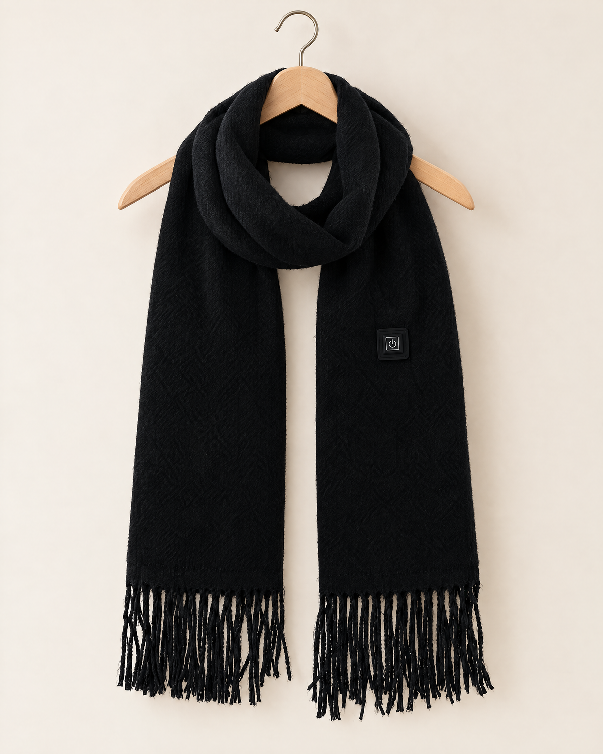 Black fringed USB heated scarf draped on a wooden hanger